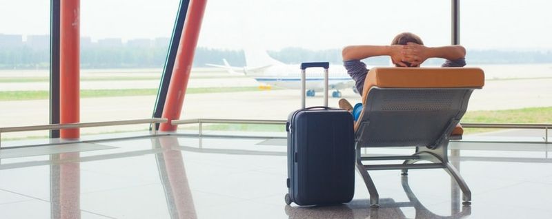 man relaxing in an airport lounge - SingSaver