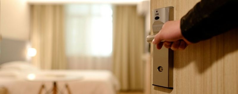 person opening a hotel room door