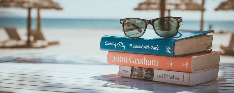 sub glasses placed on top of three books by the beach