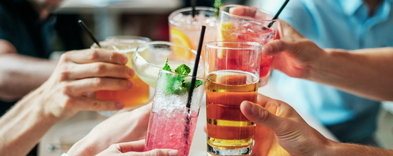 Group of friends toasting to alcoholic drinks - SingSaver