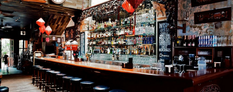 bar with display of alcoholic bottles  - SingSaver