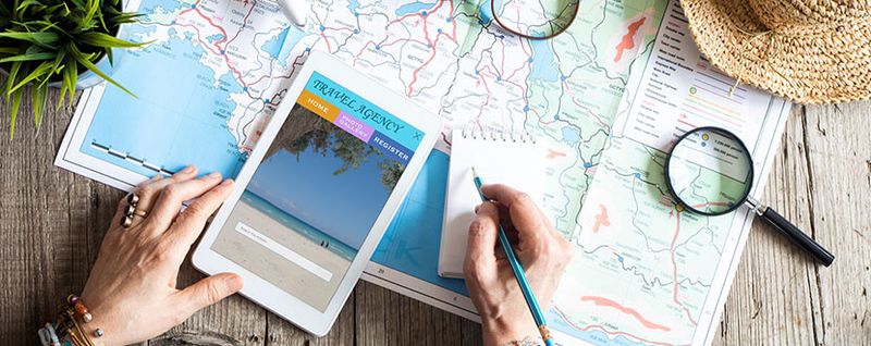 person planning a trip with map and tablet -SingSaver